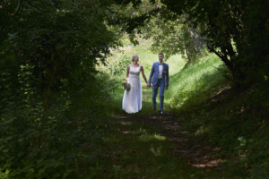 Diese Paar läuft auf einem Weg, der von Bäumen umringt ist. Es sieht wie ein Tunnel aus. Als Hochzeitsfotograf in Freiburg finde ich immer die schönsten Plätze und kann euch immer meine Ideen vorstellen