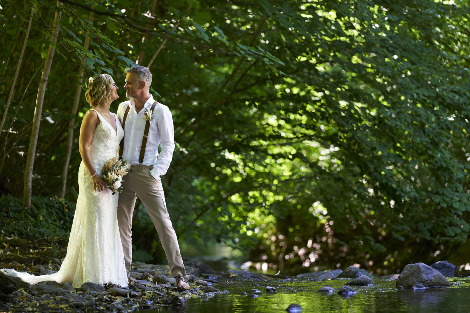 Dieses Brautpaar steht am Rande eines Baches mitten im Grünen - und meine Aufgabe als Hochzeitsfotograf ist es diese Momente auch zu inszenieren, ohne das sie gestellt aussehen, denn ihr sollte euch wohl fühlen